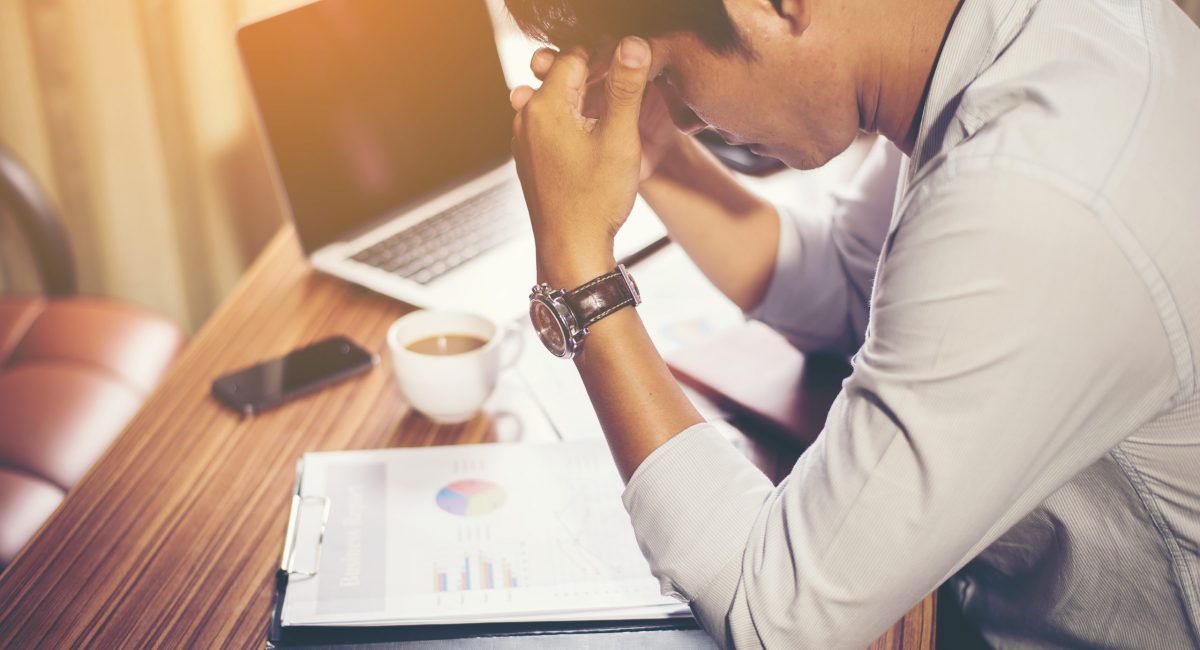 Canva - Man Holding His Head in front of Laptop